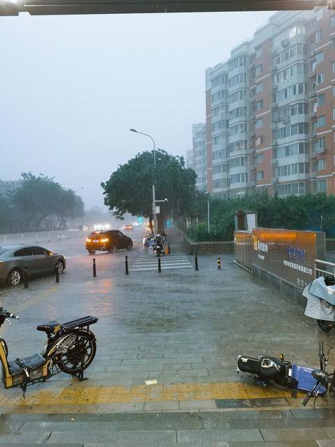 暴雨后北京街头堆积大量受损汽车，市民联手清理救援现场